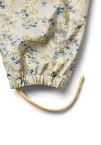 Tela con estampado floral en gris claro con flores azules y amarillas. Presenta un dobladillo elástico y un cordón amarillo. Logotipo en impresión circular.