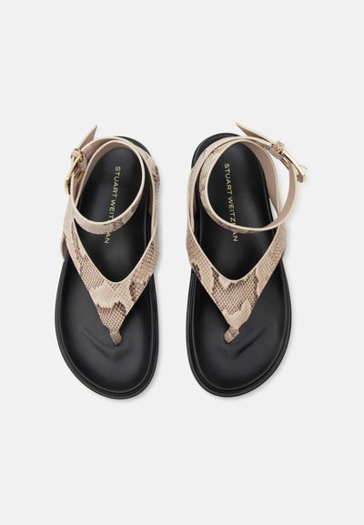 Sandales plates noires pour femmes avec brides beige à motif peau de serpent sur les orteils et boucles à la cheville, marquées « Stuart Weitzman » sur les semelles.