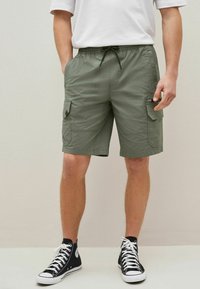 Shorts cargo kaki en tissu léger avec une ceinture élastique et un cordon de serrage. Dotés de poches latérales et d'une coupe décontractée.