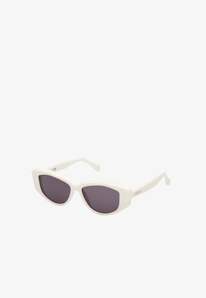 Witte plastic zonnebril met een unieke hoekige cat-eye vorm, voorzien van donkere lenzen en slanke armen. Subtiele merkaanduiding aan de zijkant.