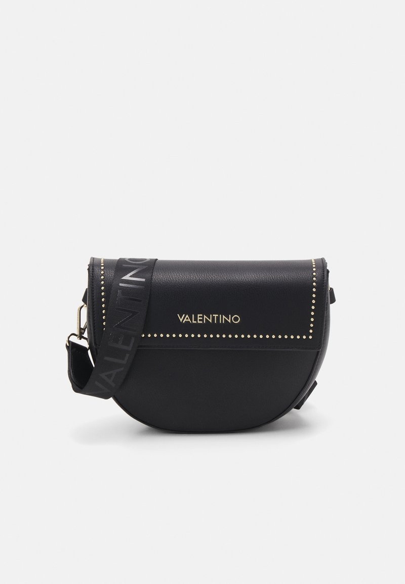 Borsa a tracolla nera in pelle con una forma curva, borchie dorate sulla patta e una tracolla con logo. Texture morbida, design moderno.