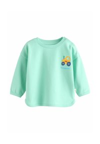 Lichtgroen peuter t-shirt met lange mouwen, met een kleine gele en blauwe vrachtwagenillustratie op de borst en drukknoopjes op één schouder.