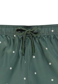 Shorts de bain verts avec une taille élastique, dotés d'un cordon de serrage et de petites broderies florales blanches dispersées sur le tissu.