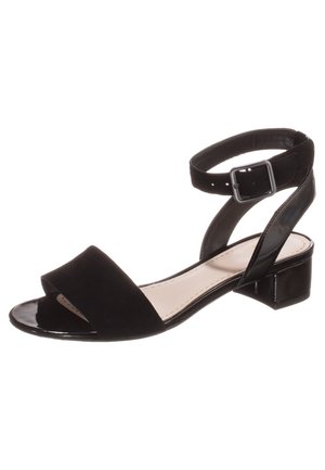 Czarne sandały z zamszowej cholewki, otwartym noskiem i regulowanym paskiem na kostce. Posiadają niski, blokowy obcas oraz błyszczący detal z lakierowanej skóry na pasku.