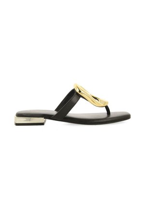 Sandalias planas negras con un acento metálico dorado, presentan un diseño de tiras entre los dedos y un elegante tacón rectangular. Textura de cuero suave.