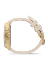 Reloj dorado con esfera cuadrada, correa de silicona beige suave, bordes redondeados y un botón lateral para ajustes. Diseño minimalista.