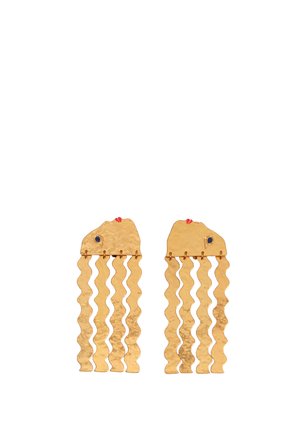 Pendientes de tono dorado con forma de rostros estilizados, con hebras onduladas colgantes y pequeños detalles de esmalte azul y rojo en la sección superior.