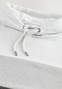 Hellgrauer Hoodie mit weißen Kordeln und Metallösen, weiche Stoffstruktur und einem „NEXT“-Markenlabel innen am Kragen.