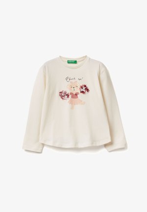 Camicia a maniche lunghe color crema in morbido cotone con un personaggio orso stampato, pompon, un cuore e testo che dice "Rallegrati!"