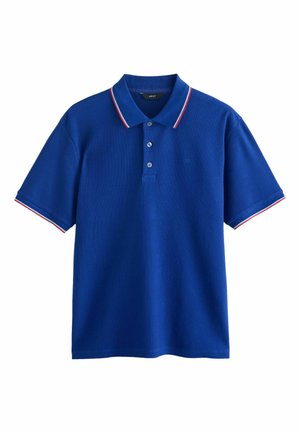 Modré polo tričko s krátkym rukávom, golierom a manžetami ozdobenými červenou a bielou farbou, tromi gombíkmi pri výstrihu a nenápadným logom na hrudi.