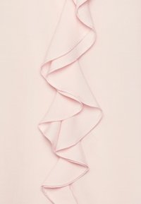 Tissu rose clair présentant un volants proéminent sur un côté, texture lisse avec une finition délicate, sans éléments métalliques ni accents visibles.