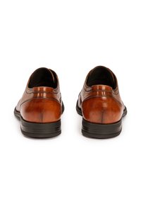 Chaussures en cuir marron avec une finition lisse, bout rond, talon bas et semelle extérieure en caoutchouc noir. Présente une couture subtile le long du talon.