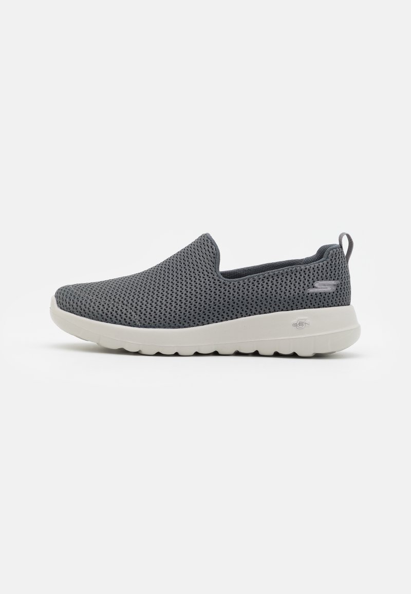 Des chaussures à enfiler en maille grise avec une finition texturée, dotées d'une semelle en caoutchouc blanche et d'une petite languette au talon pour un enfilage facile.
