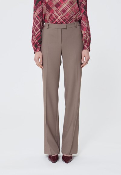 Brown tailored trousers with a straight leg design, featuring a smooth texture and crease down the front, paired with pointed burgundy shoes.