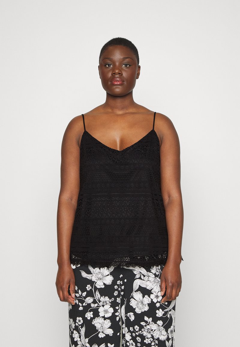 Black lace camisole with thin straps, featuring a v-neckline and textured floral pattern, paired with black and white floral pants.