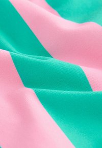 Tekstiil, millel on rohelised ja roosad diagonaalsed triibud, sile tekstuur ja kerge läige, paigutatud korduvasse mustrisse.