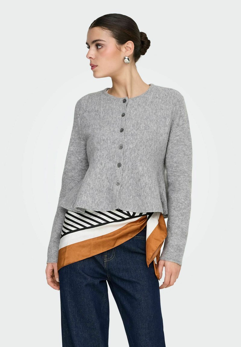 Sivi vuneni kardigan s okruglim izrezom, zatvaranjem sprijeda na kopčanje i proširenim rubom. Uparen s prugastim i jednobojnim šalovima.