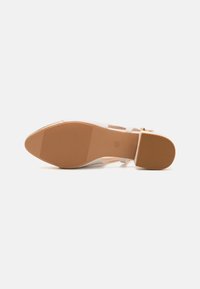 Scarpa con tacco in plastica trasparente, con suola in gomma beige, dotata di una cintura regolabile alla caviglia e texture verticale a righe sulla suola.