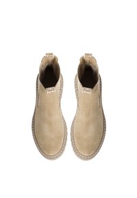 Beige Wildleder-Ankle Boots mit elastischen Seitenelementen, runder Zehenform und kontrastierenden Nähten um die Sohle. Zwei Ziehlaschen oben.