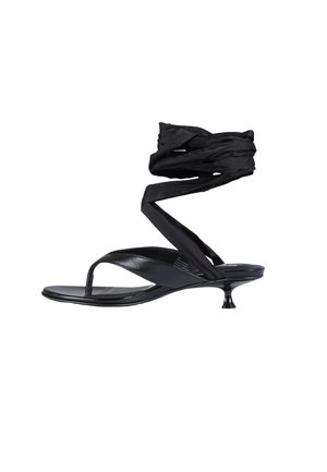 Sandale noire en cuir à lanière avec un petit talon et de longues lanières en tissu noir enroulées autour de la cheville.