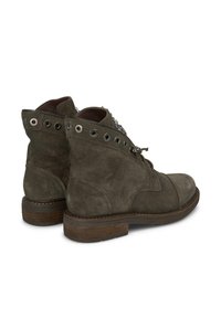 Stivaletti in suede grigi con punta arrotondata, lacci frontali, occhielli decorativi e un tacco in legno basso e impilato. Presenta una cerniera sul lato.