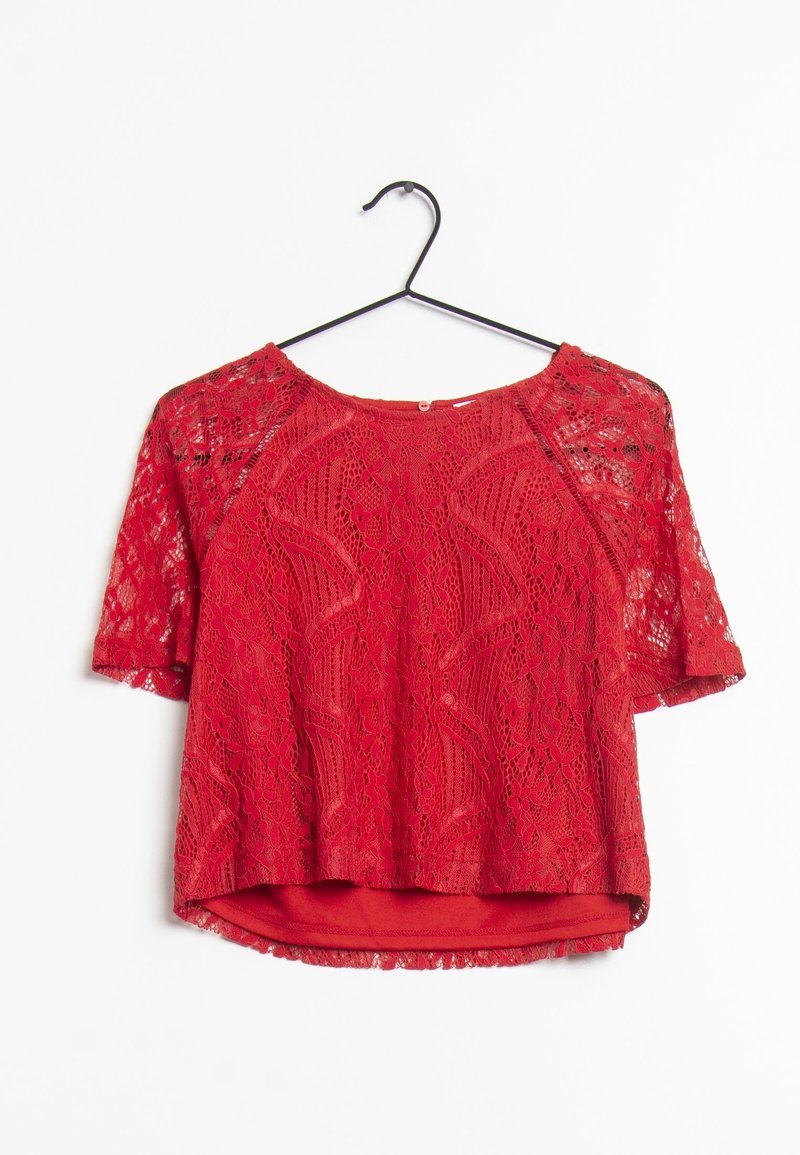 Cropped top in pizzo rosso con maniche corte, caratterizzato da un motivo floreale e un collo rotondo. La fodera sotto il pizzo è in un tessuto rosso uniforme.
