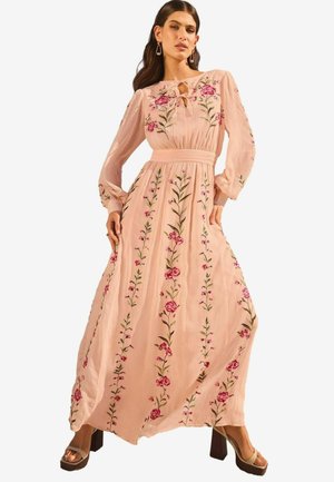 Abito maxi floreale lungo, rosa, con maniche lunghe, scollatura a chiave, e ricami verticali di fiori e foglie, tessuto testurizzato e cintura in vita.