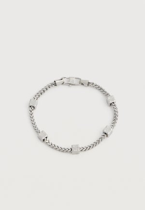 Srebrna zapestnica z verižico, okrašena s petimi enakomerno razporejenimi kockastimi kroglicami na belem ozadju, z zaponko za zapiranje.