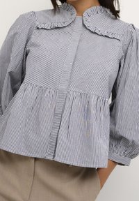Blauwe en witte gestreepte blouse met een gerimpelde kraag, pofmouwen en een peplum taille. Bevat verticale en horizontale streep patronen.