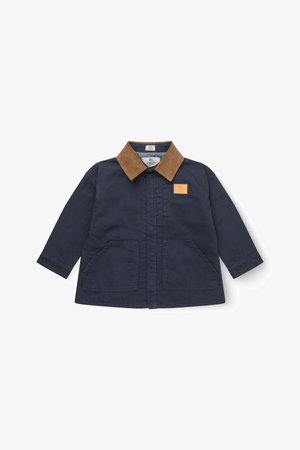 Tengerészkék gyerekdzseki barna kordbársony gallérral, két első zsebbel és egy kis barna folttal a mellkasán.