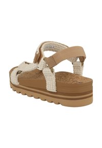Beige platform sandal with woven upper, cork footbed, adjustable straps, and rubber sole featuring a wave pattern for traction.