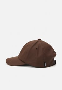 Casquette de baseball en nylon marron avec visière incurvée, œillets de ventilation, sangle réglable à l'arrière et étiquette de logo sur le côté.