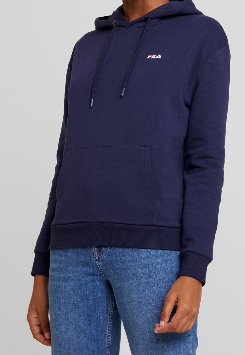 Navy blue hoodie made of soft fabric, featuring a front kangaroo pocket, drawstring hood, and a small embroidered logo on the chest.