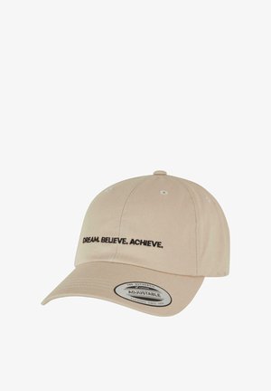 Adjustable beige baseball cap made of fabric, featuring black embroidered text "DREAM. BELIEVE. ACHIEVE." on the front. Curved brim.