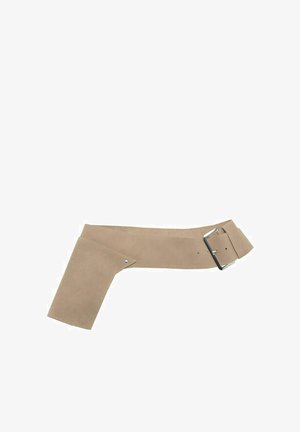 Širok bež semiš pas z asimetričnim preklopom in srebrno pravokotno sponko na belem ozadju.