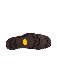 Ruskea mokkanahkakenkien pohja, jossa on voimakkaasti teksturoitu kuminen Vibram-pohja, jossa on sahalaitakuviota ja näkyvä keltainen Vibram-logo.
