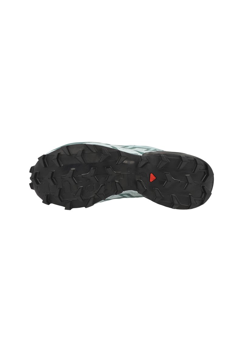 Semelle en caoutchouc noir avec des profondeurs, semelle intermédiaire gris-bleu présentant un motif texturé, et un détail central d'accent rouge.