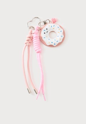 Porte-clés avec un charm donut rose avec un glaçage blanc et des vermicelles colorés, attaché à des cordons tressés roses et un anneau en forme de cœur en argent.