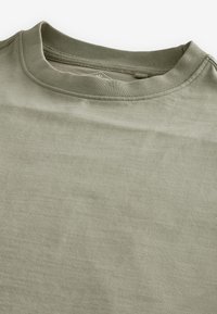 Kortærmet T-shirt med rund hals i lys olivengrøn, lavet af blød bomuld med en glat tekstur og enkelt design med forstærket krave.