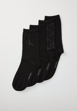 Four pairs of black Calvin Klein socks arranged overlapping, featuring logo initials and brand name on each pair.