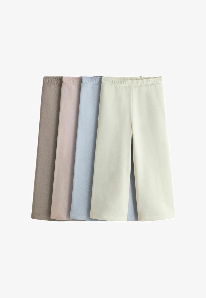 Četras vienkāršas šorti ar elastīgu vidukli bēša, gaiši rozā, gaiši zilu un baltu krāsā, sakārtotas blakus uz baltas virsmas.