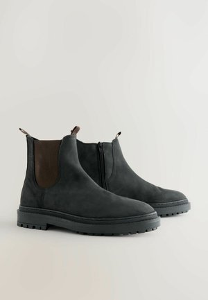 Grå mocka Chelsea-boots med elastiska sidopaneler, dragkedjestängning och en robust gummisula med mönster för bra grepp.