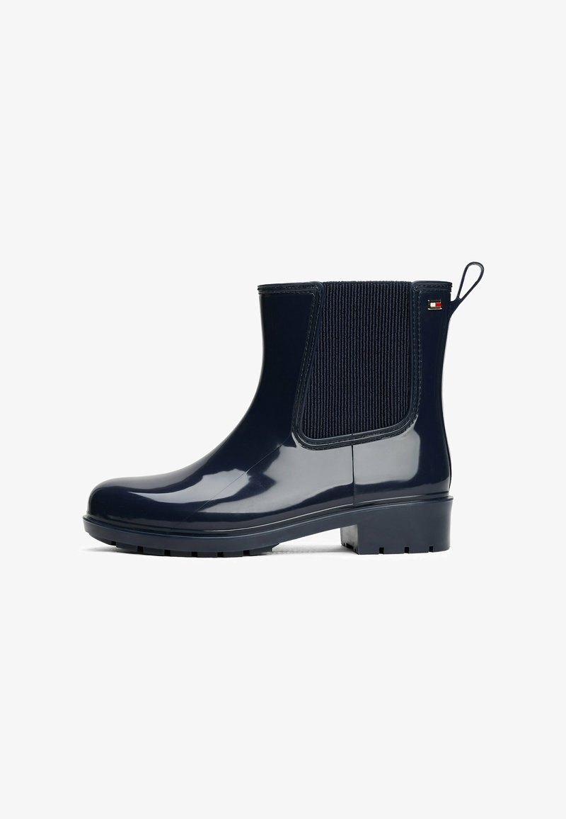 Bottes en caoutchouc bleu marine à cheville avec une finition lisse, des panneaux latéraux élastiques et une languette. Semelle robuste avec une traction pour les surfaces mouillées.