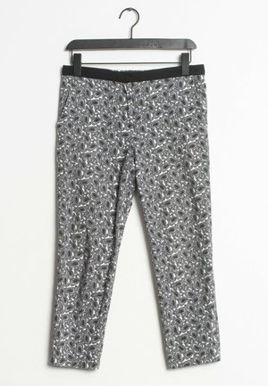 Pantalones de patrón en blanco y negro con diseño de cachemira, con una pretina elástica y ajuste slim. La tela tiene una textura suave.