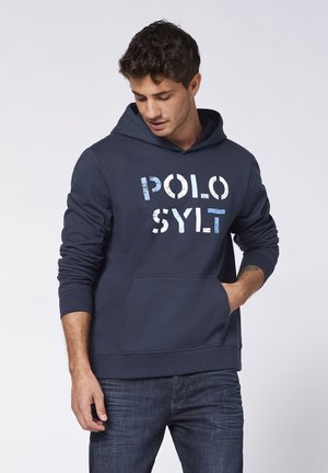 Marineblaue Kapuzenjacke aus weichem Stoff, mit einer vorderen Kängurutasche und gerippten Bündchen, mit "POLO SYLT" in blau-weißer Schrift bedruckt.