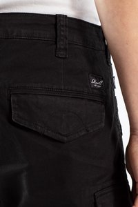 Shorts de mezclilla negra con un bolsillo trasero que presenta una solapa curva, detalles de costura y una etiqueta con "Reell est. 1997."