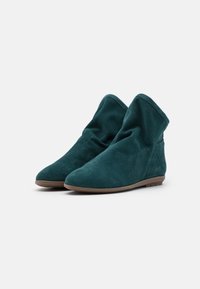 Teal nubuck ankelstøvler med en slittet design, rund tå og flad gummisål. Glat tekstur med minimal syning.