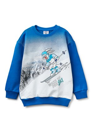 Niebieska bluza z długim rękawem z kreskówkowym królikiem na nartach, noszącym kask i gogle, na tle zaśnieżonych gór oraz napisem „WAKE UP FOR SKI”.