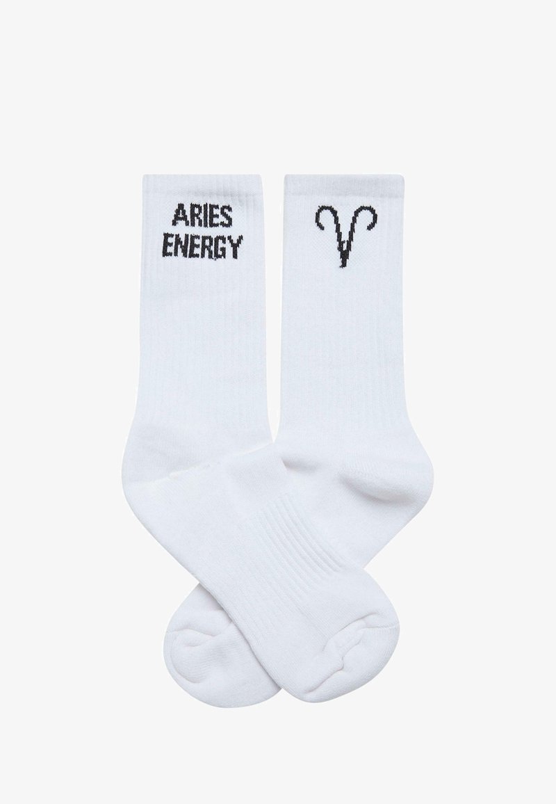 White cotton blend socks featuring black text "ARIES ENERGY" on one and a black Aries symbol on the other. Ribbed texture at the top.