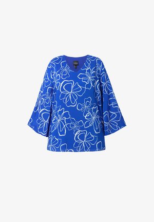 Sininen tunika, jossa on V-pääntie ja kellot kasvavat hihat, ja siinä on valkoisia kukkakuosit koko kankaan alueella. Valmistettu kevyestä materiaalista.